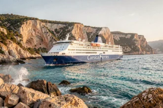 Ferry Corsica Ferries naviguant le long des côtes rocheuses de la Méditerranée avec vue panoramique sur la mer turquoise